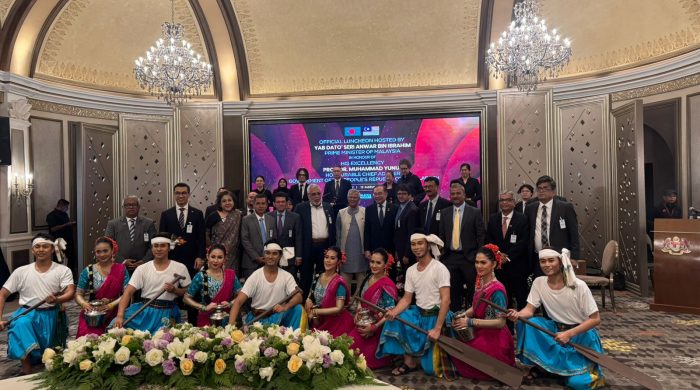 Malaysian Prime Minister Anwar Ibrahim and Bangladesh Chief Adviser Professor Muhammad Yunus pose for photograph with performers after lunch at the residence of the Malaysian Prime Minister in Putrajaya on Tuesday.
